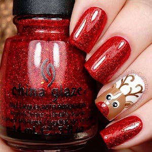 Nail art rouge pailleté avec motif élan de Noel