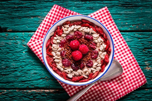 Le smoothie bowl fraises, amandes, noix de coco, raisins secs et muesli